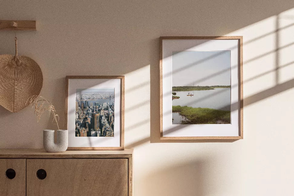 Light wood framed landscape photo print with white border, showing lake and red boat