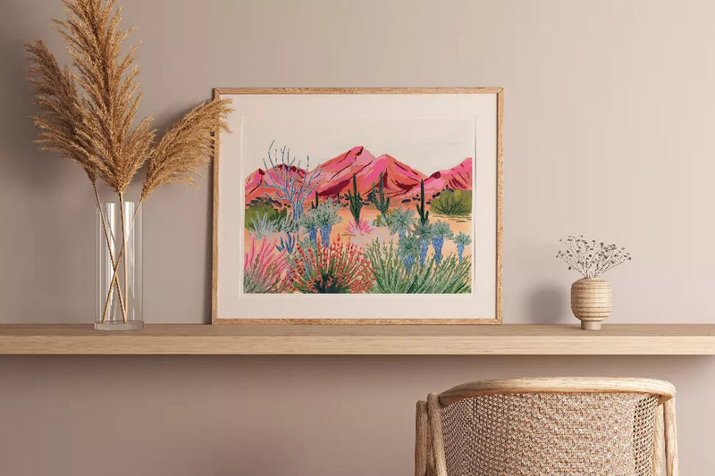 Framed desert landscape art print in a wooden frame with pink mountain scenery