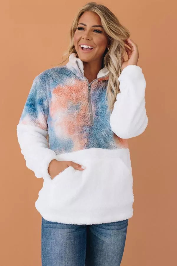 Fuzzy tie-dye half-zip pullover with blue-orange cloud pattern and white sleeves, kangaroo pocket