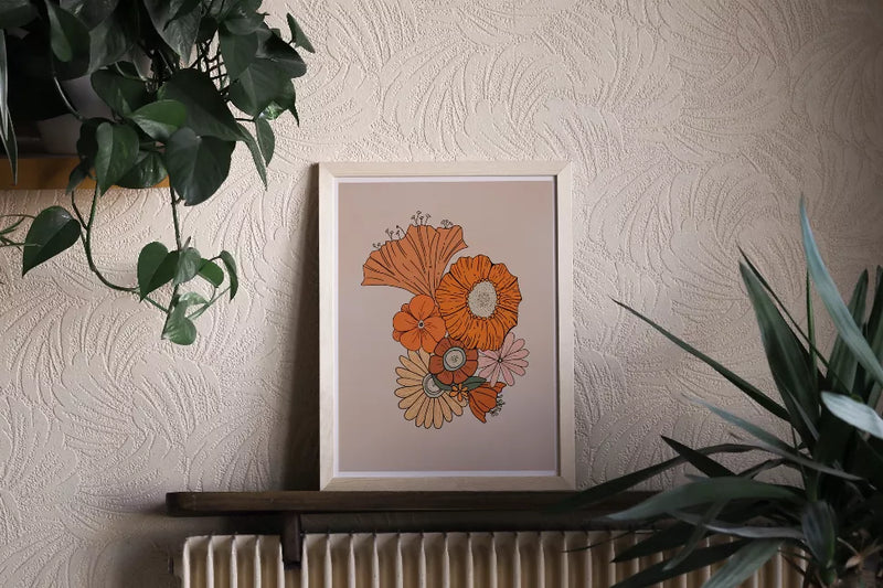 Framed retro floral wall art print centered on a wall with greenery and a radiator below