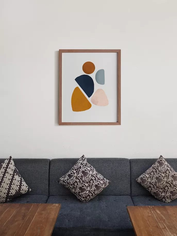Wood-framed abstract wall art with orange, navy, light blue and beige shapes