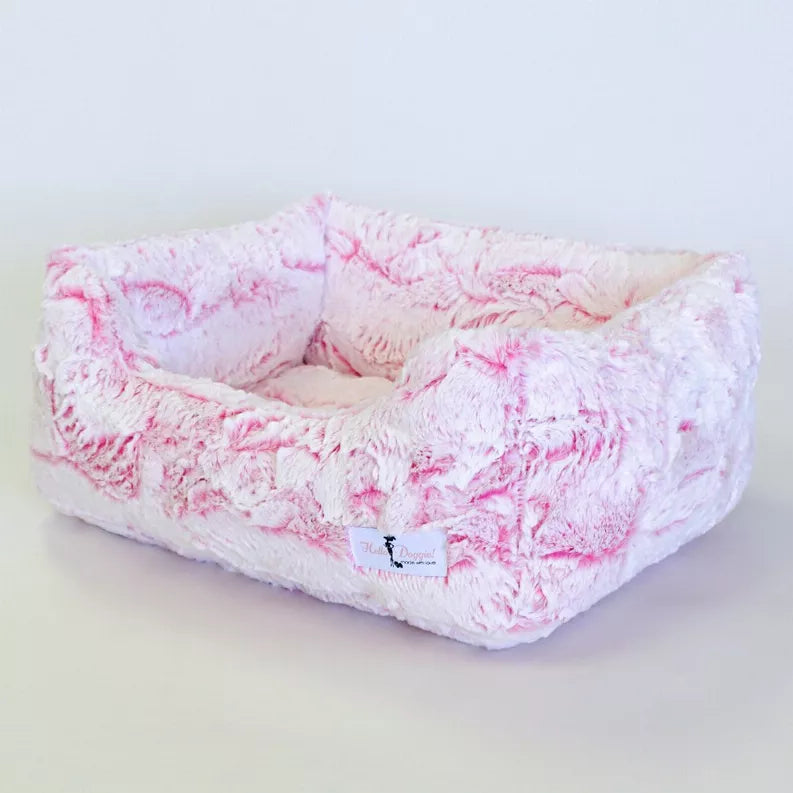 Plush oval dog bed, pink-and-white fuzzy cover with cushioned center