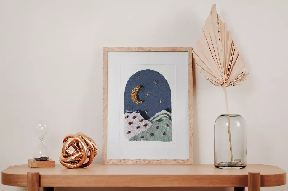 Framed moon and star wall art on shelf, textured blue night scene with crescent moon