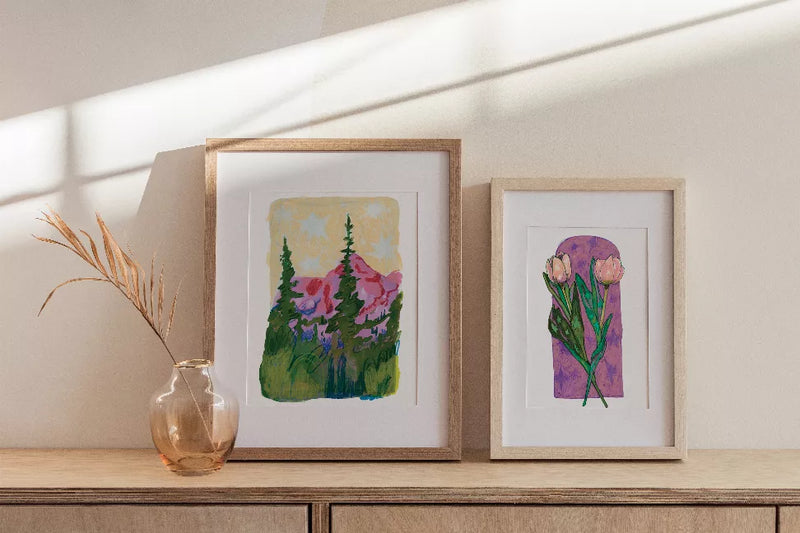 Pair of framed nature art prints featuring pine trees and blooming flowers