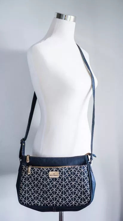 Navy patterned crossbody bag on mannequin, adjustable strap and front zip pocket