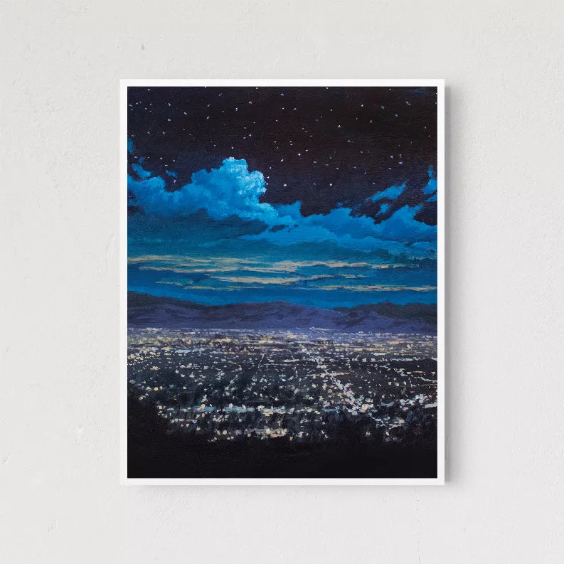 Framed night landscape print with white mat, light wood frame, blue cloud-filled sky