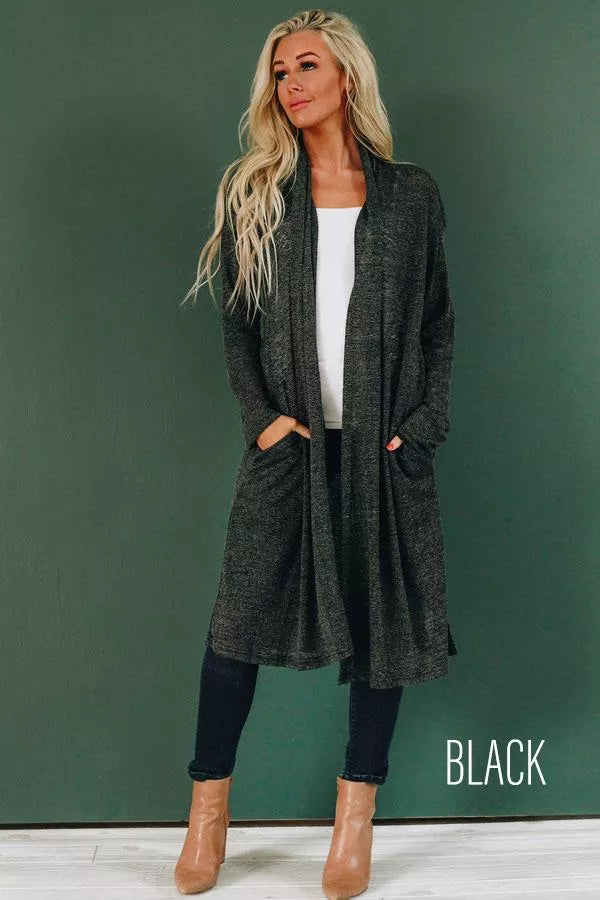 Slouchy black knit cardigan with open front, long sleeves, and side pockets