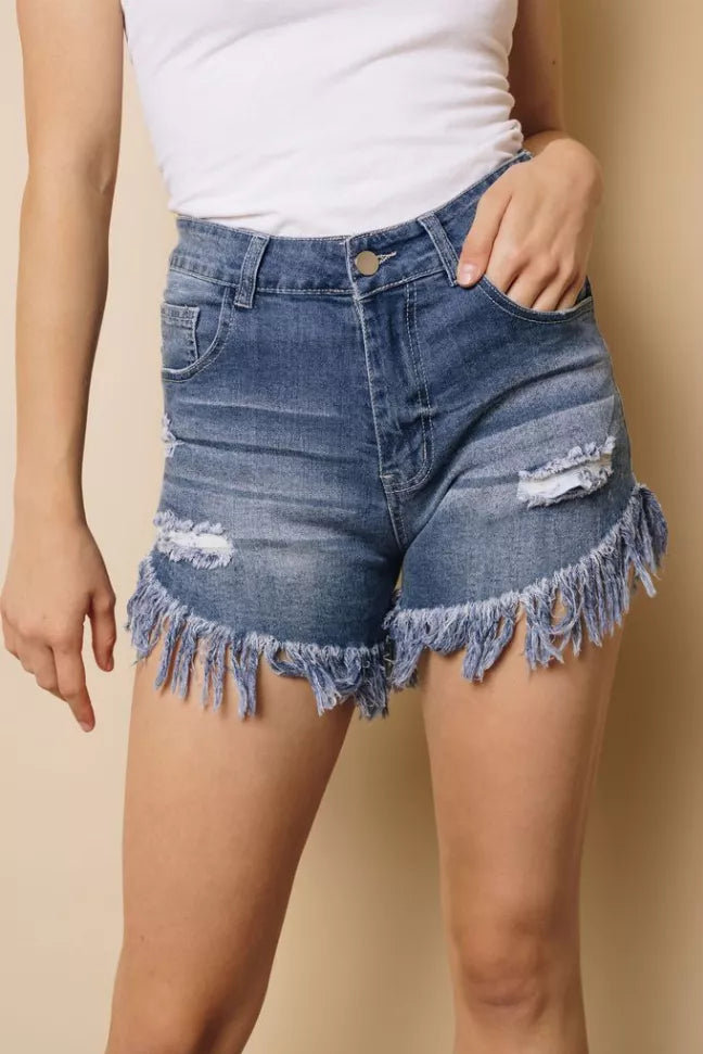Blue distressed denim shorts with frayed tassel hem, front pockets and button