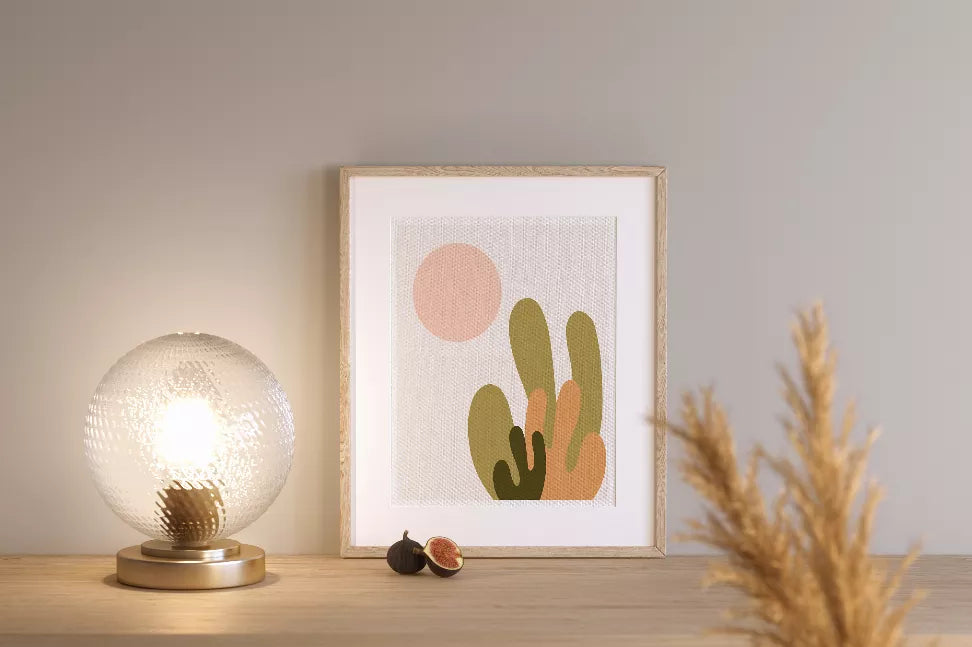 Framed desert cactus art print with green and tan cacti, pink sun, gold wood frame