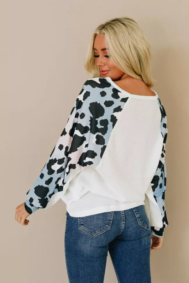 Thermal top with scoop back, white body and black cow-print long sleeves and cuffs