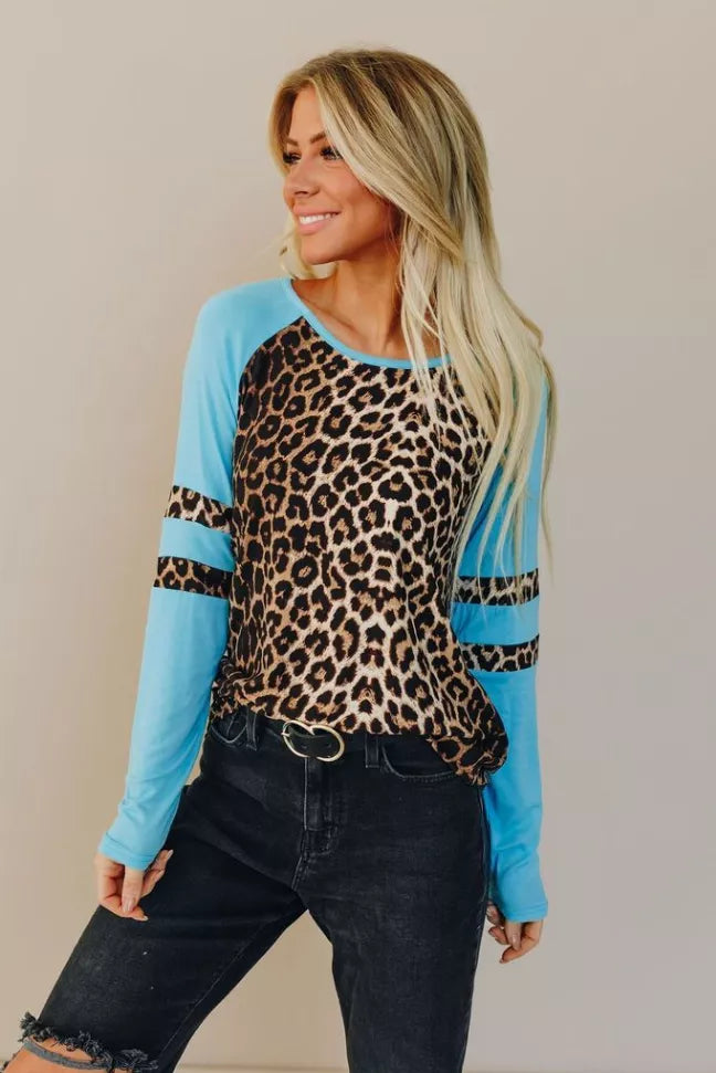 Leopard-print raglan tee with sky-blue sleeves and black-striped cuffs, round neckline.