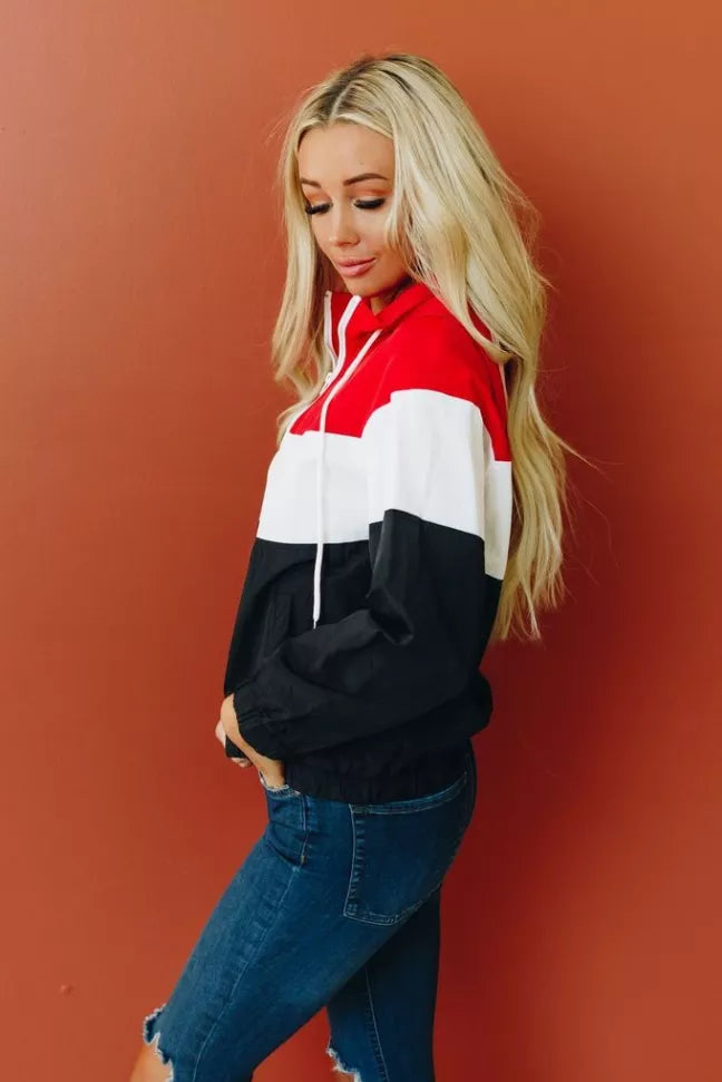 Colorblock hooded windbreaker, side view; red, white, and black quarter panels