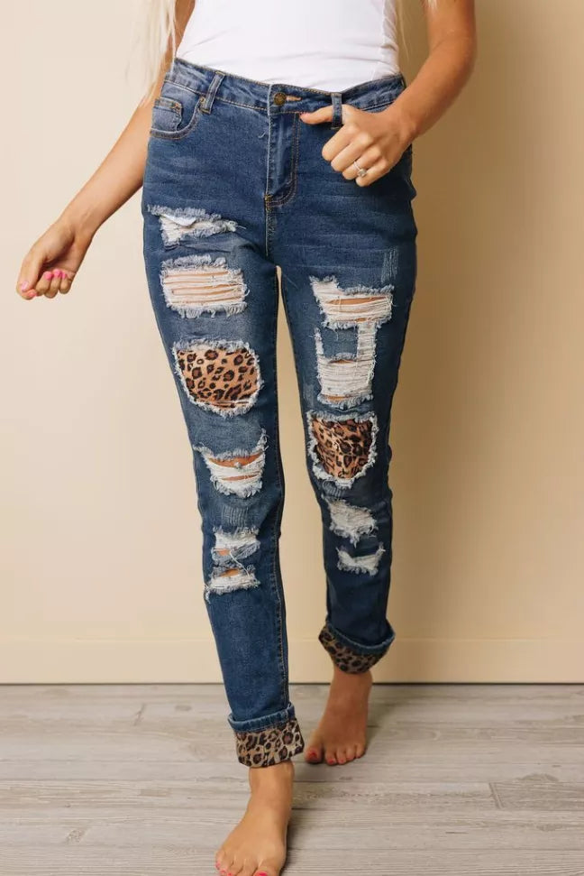 Blue ripped jeans with leopard print patch at thighs and frayed knee tears