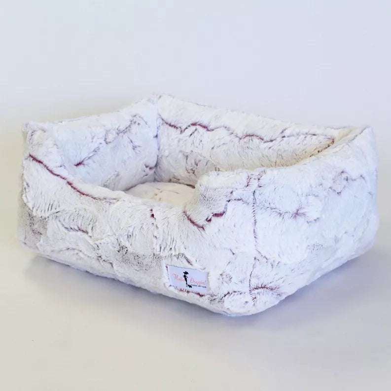Light plush rectangular dog bed with cushioned bolster sides