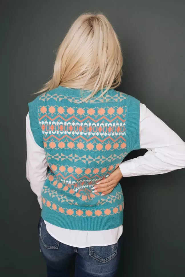 Back view: teal knitted sweater vest with ribbed trim and orange tribal pattern