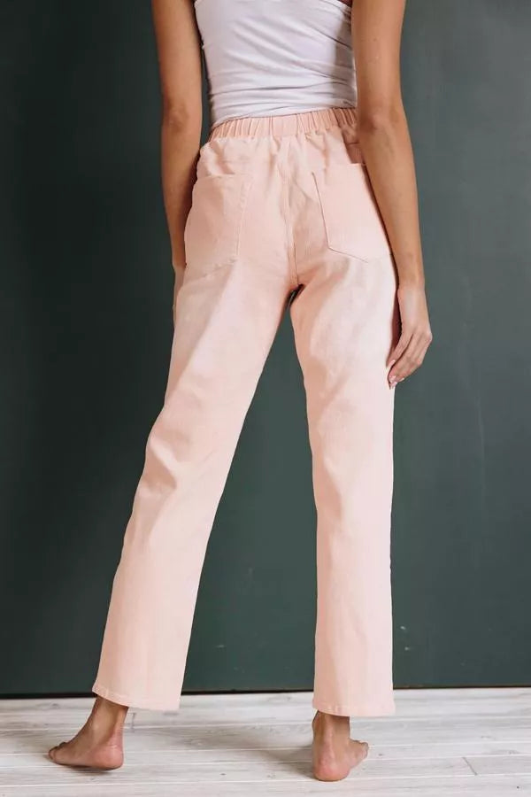 Light pink denim joggers, side view with elastic drawstring waist and distressed knee areas