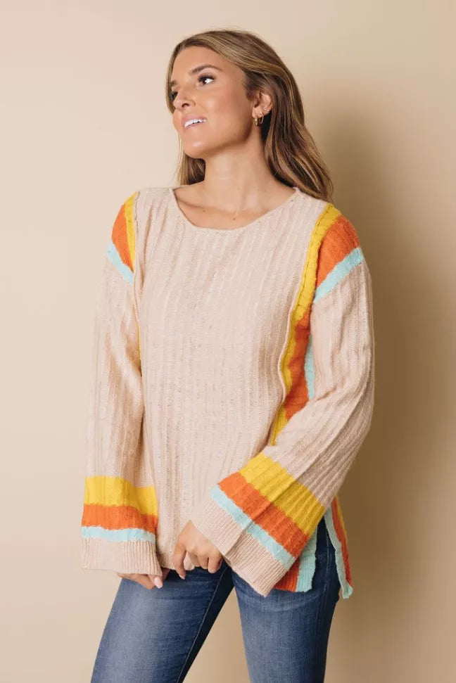 Cream knit sweater with rainbow striped bell sleeves and round neckline, relaxed fit