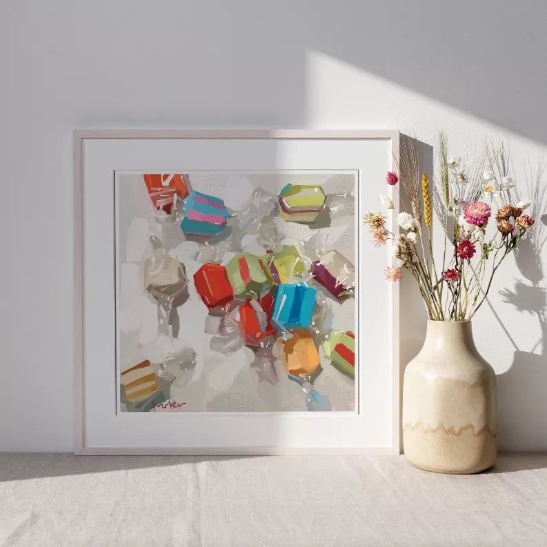 Framed abstract wall art leaning beside flower vase, multicolor geometric pattern