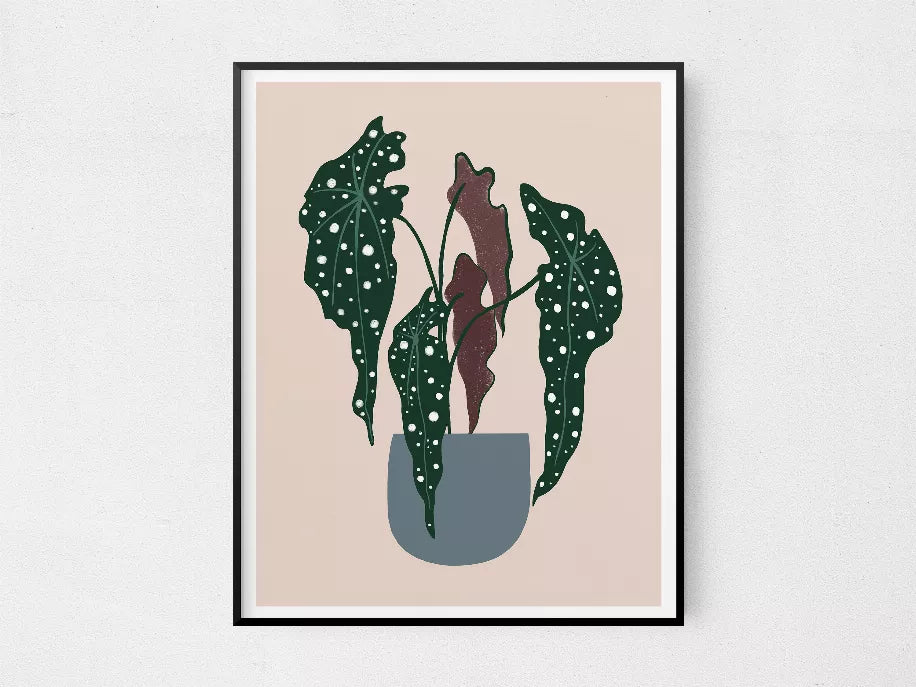 Framed botanical wall art with polka-dot leaves in dark green and a muted beige pot