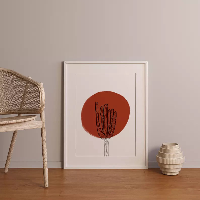 Framed cactus wall art with rust-red circle and line-drawn desert plant, white frame