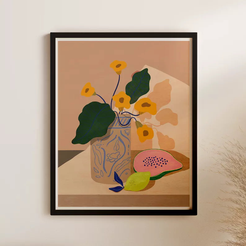 Framed botanical wall art with vase and fruit accents, black frame on wall