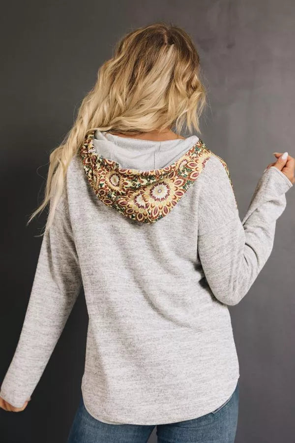 Light gray hoodie with tribal print around hood, long sleeves, kangaroo pocket