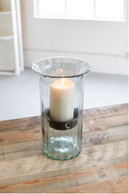 Clear ribbed glass candle cylinder with lit cream wax candle and rustic insert