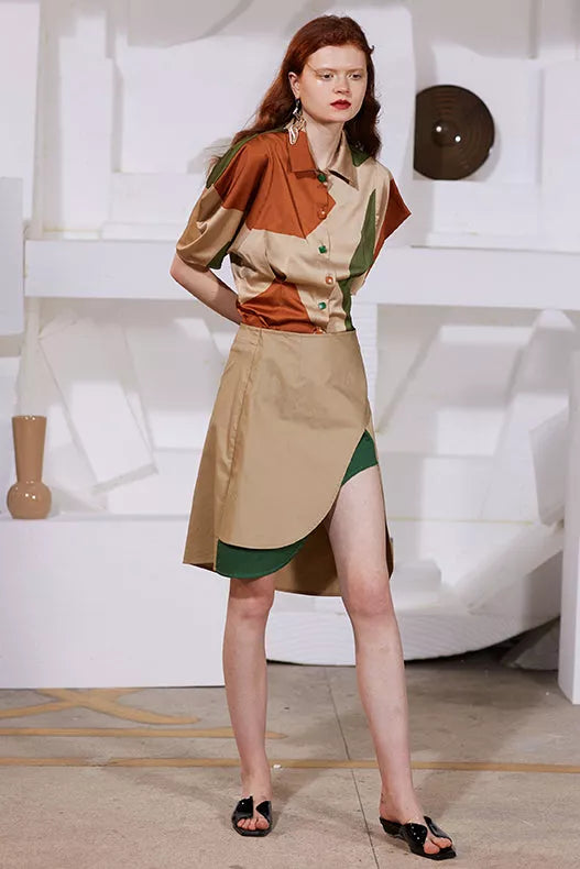 Rimless high front open slit skirt in beige with button front and green underlay