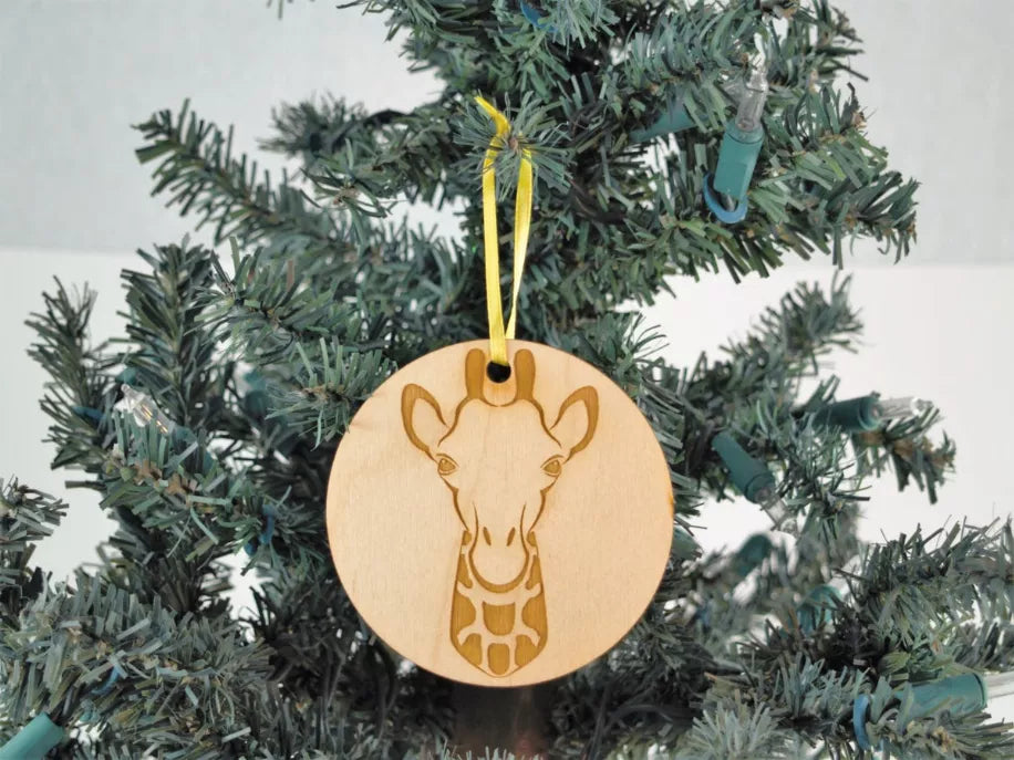 Round unfinished wooden giraffe ornament with hanger loop and yellow hanging ribbon.