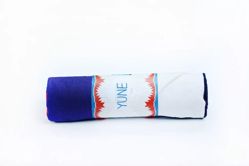 Rolled yoga towel in dark blue with white patterned band and YUNE branding