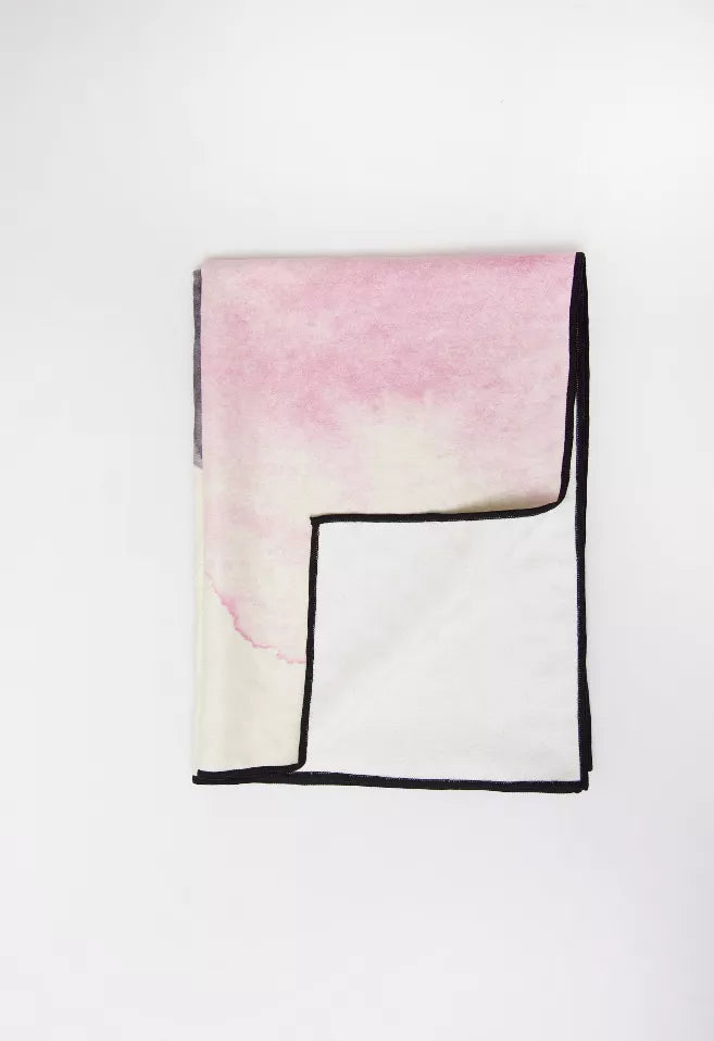 Yoga towel folded square with pink-to-white watercolor and dark border edges.