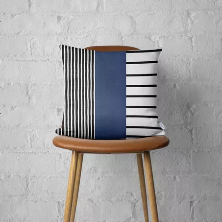Striped throw pillow cover on chair seat, navy faux leather panel with black-and-white stripes