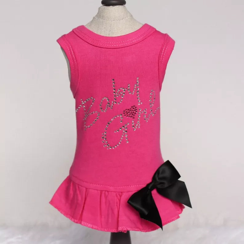 Sleeveless fuchsia dress with rhinestone floral swirl, ruffled hem, and black bow