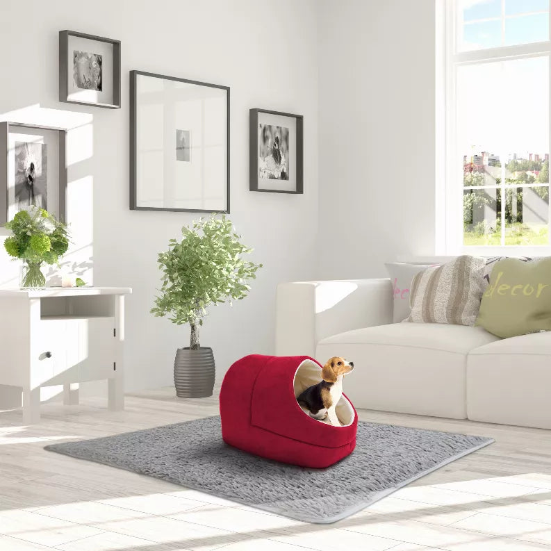 Red cat cave bed with round entrance and cream trim, pet inside on a gray mat