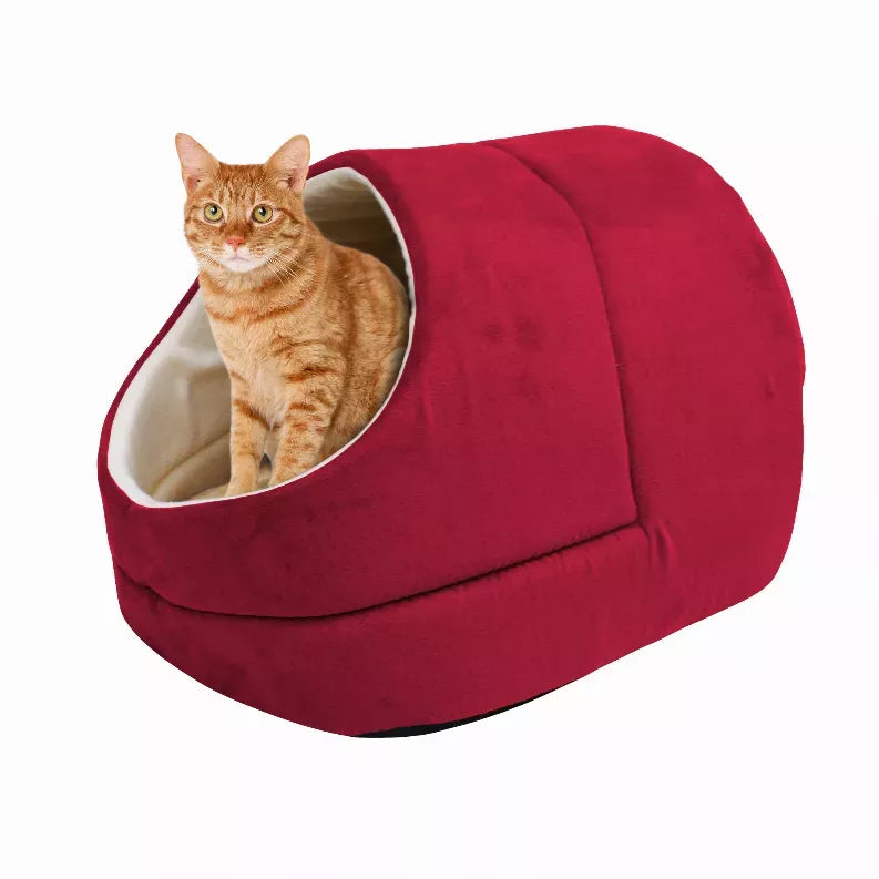 Red cat cave bed with cream-trimmed entrance, orange tabby cat sitting inside