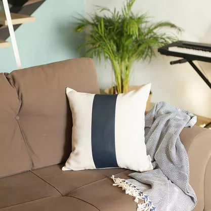 Throw pillow cover with white face and dark blue vertical stripe, faux leather texture