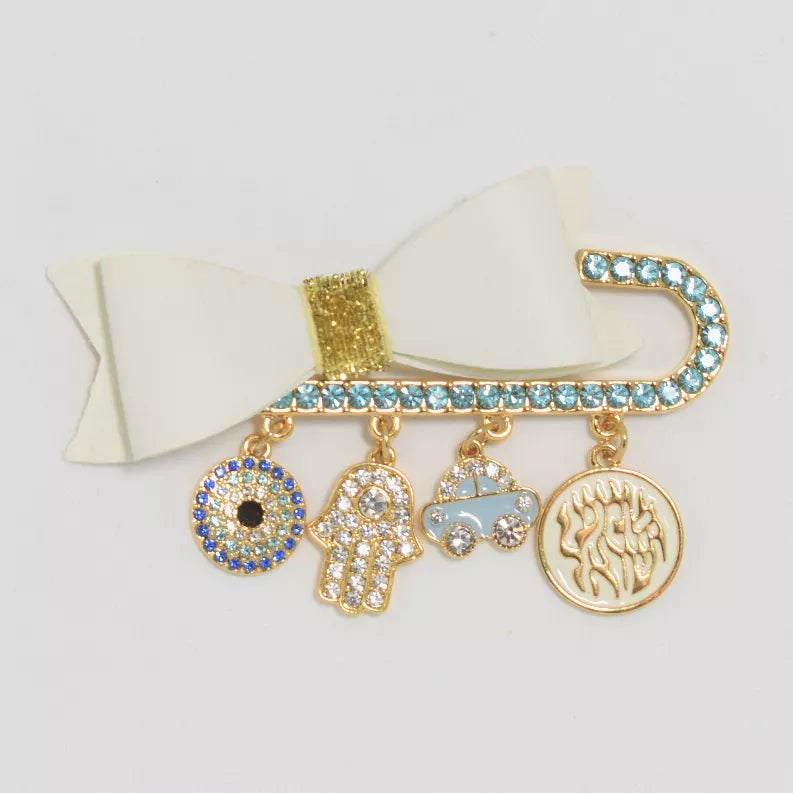 Rhinestone baby pin with cream bow, blue stones, and dangling charm pendants