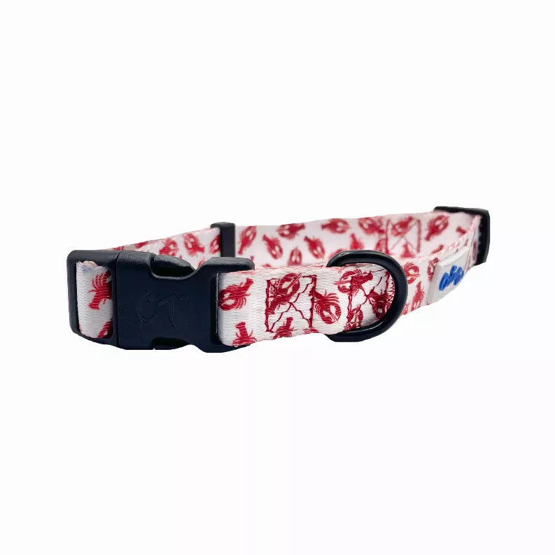 Red lobster-pattern dog collar with black buckle and D-ring on white fabric