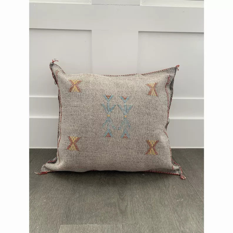 Gray square throw pillow cover with blue and orange geometric embroidery, tassel corners