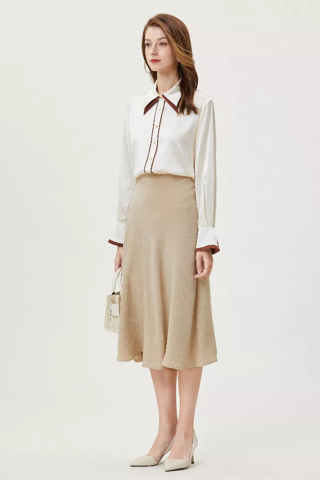 White silk button-up shirt with brown tie collar and cuffs, styled with a midi skirt