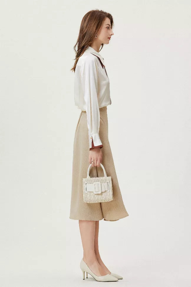 White silk shirt with brown tie-neck collar, back view with beige midi skirt