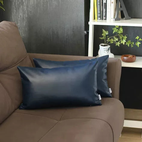 Blue faux leather throw pillow on beige sofa, with matching back pillow