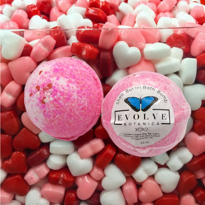 Pink bath bomb with white speckles; round pair shown