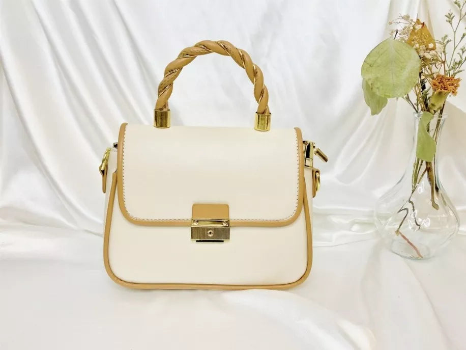 Cream small handbag with braided handle and gold lock clasp, shown front-on.