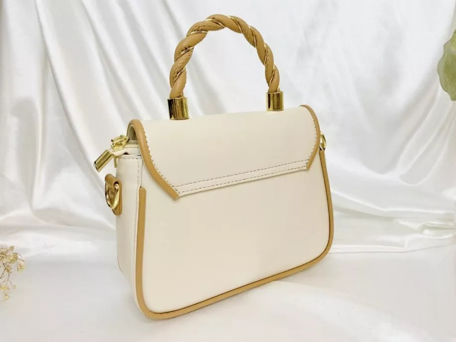 Cream small handbag with braided handles, gold hardware, and long side strap.
