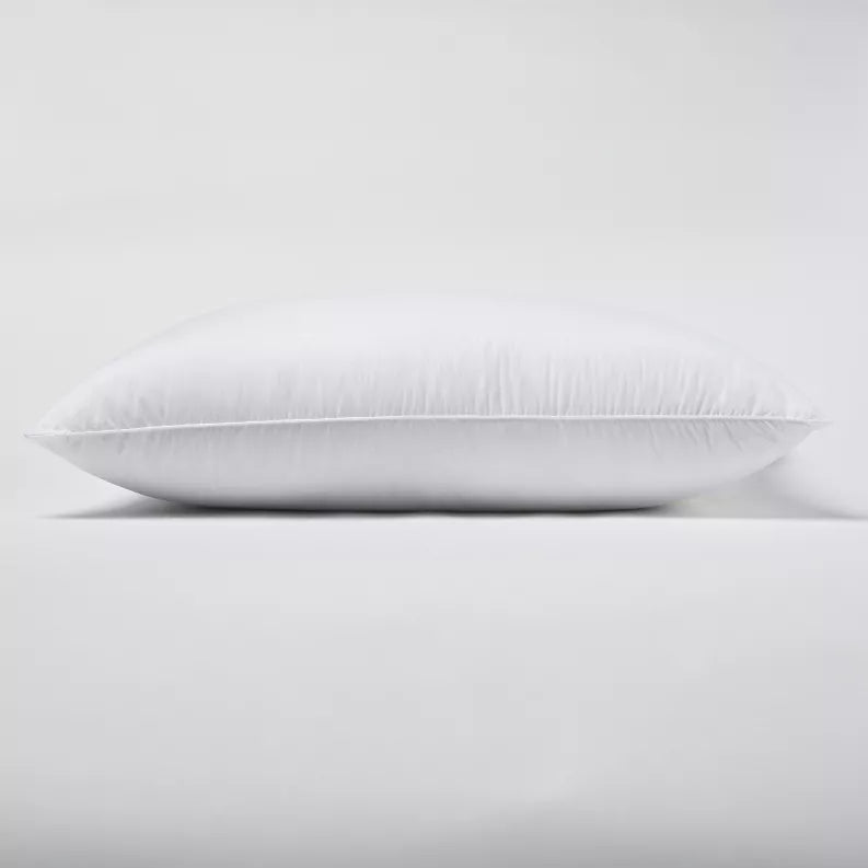 Hotel chamber pillow in white, smooth fabric, standard oval shape, side view