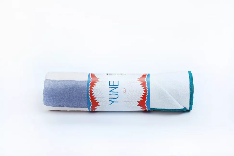 Rolled yoga towel with blue body, coral trim, turquoise end and YUNE label