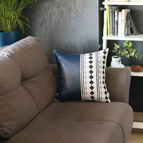 Blue faux leather throw pillow on sofa with gray patterned stripe and black diamonds