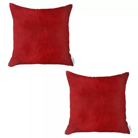 Pair of red square faux leather throw pillows on a plain white background