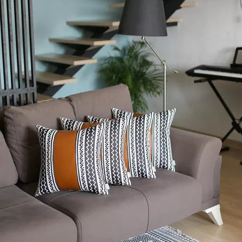 Black-and-white zigzag striped throw pillows on a gray sofa with tan accent panel